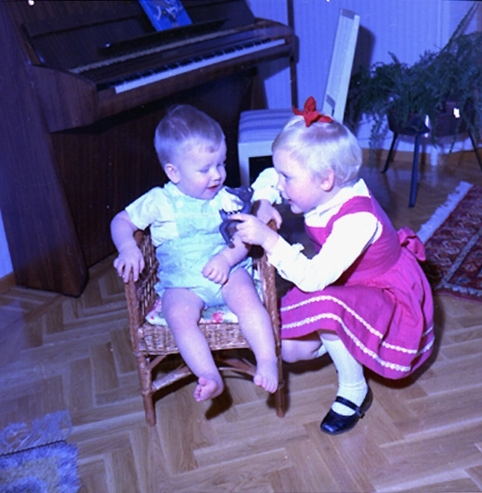Rumsinteriör, två barn vid pianot.
Bertil Larsson