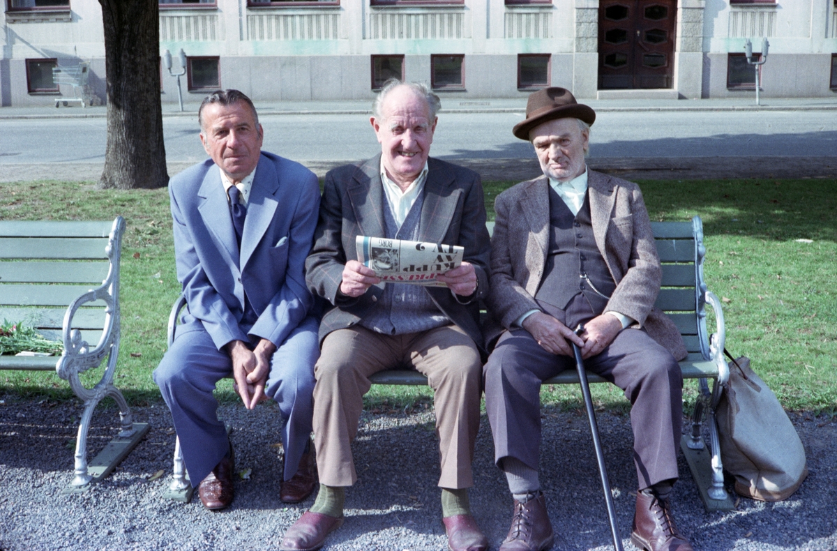 Olle Blom, i mitten, sitter på en parkbänk på Esplanaden i Huskvarna och läser i tidningen Expressen om en kupp av TV2.