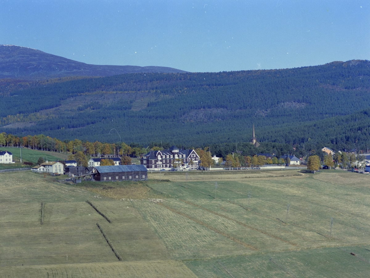 Flyfoto, tettsted, fra v. gårdsbruket Søre Dombås, nå også nevnt som Domaas nistugu, Dombås Turisthotell og Dombås kirke.