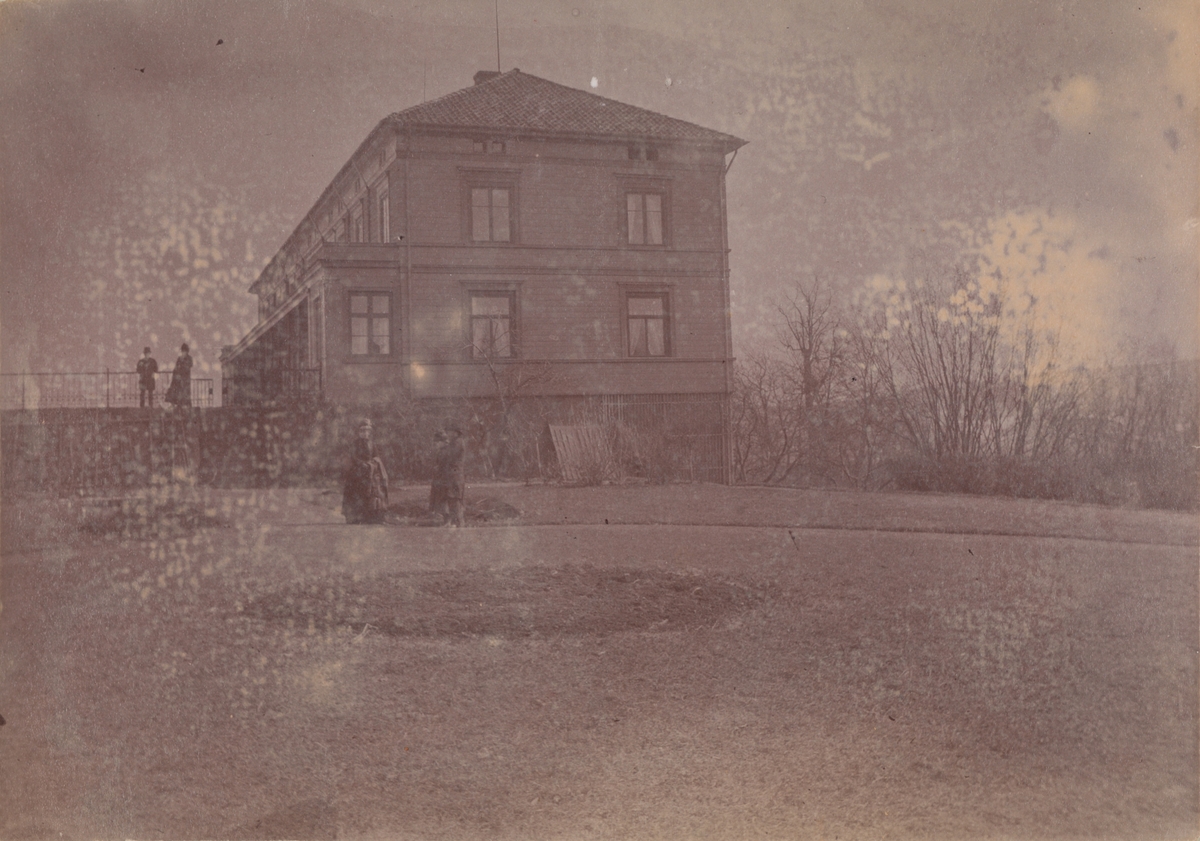 Linderud Gård hovedhus og fem mennesker sett fra den victorianske hagen.