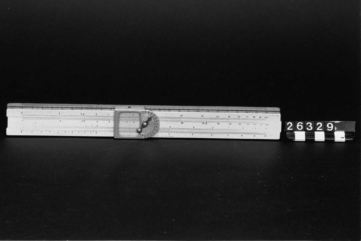 Räknesticka av buxbom med skalor av celluloid och löpare av aluminium med decimalmarkör. Märkt D.R.G.M.