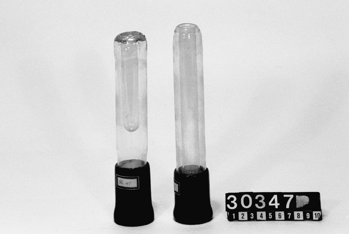 Två mindre vacuumkärl, Dewar-flaskor, cylindriska med fot och trä.  Höjd: 220 resp. 210 mm, diameter: 33 resp 35 mm.
