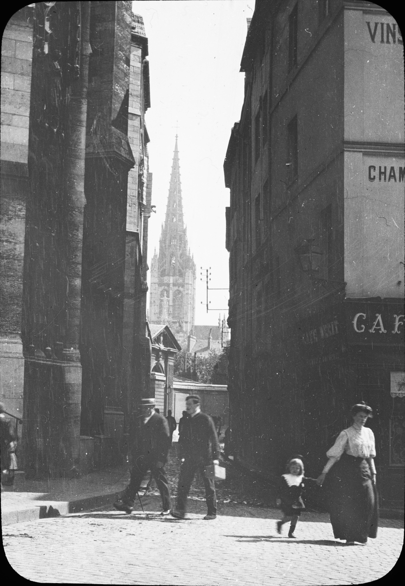 Skioptikonbild med motiv från gata i Rouen med Église St. Maclou i bakgrunden.
Bilden har förvarats i kartong märkt: Resan 1908. Rouen 7. III. Text på bild: "L'Eglise St. Maclou".