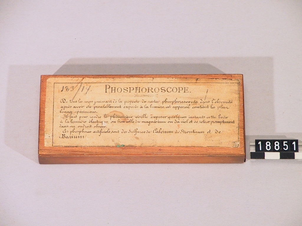 "Phosporoscope" med sulfider av calcium, barium och strontium, i igensmälta glasrör, i låda av trä. Fransk text på undersidan av lådan.