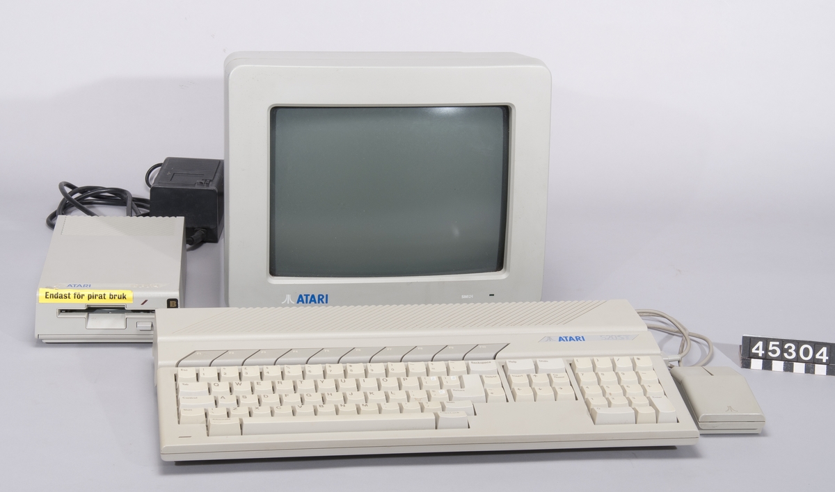 Atari 520 ST  Grått tangentbord med integrerad dator. Processor: Motorola 68000, klockfrekvens 8 MHz. Bussbredd: 32/16 bit 512 KB RAM. Ljudkrets: Yamaha YM2149F Operativsystem Atari TOS  Ser nr A1 1010711 1985  Skärm Atari model SM124 nr N1954467294 tillv maj 1999 i Korera  Mus Atari STMI nr P2855016079  Diskettenhet Atari SF314 ser nr A1645006861 med nätenhet ty PS 32 daterad 2-85  Diskettlåda med 31 disketter, bland annat program (Cubase, Notator, Word) och spel (Lemmings), PC-emulator och DOS, Midi-filer och ljudbibliotek.  Program i förpackning, 2st disketter: Atari ST utilities, RAM disk & Print spooler, tillv Talent Computer Systems, Skottland