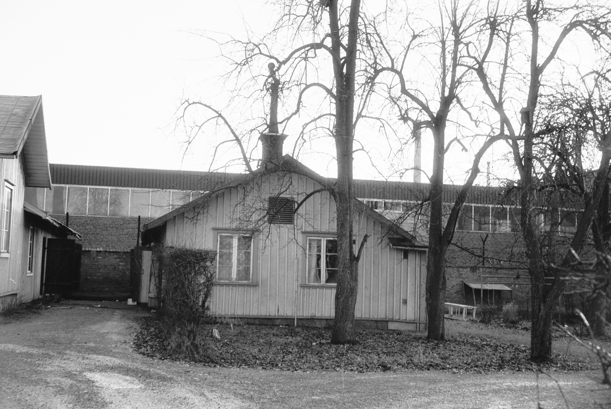 Gaveln på ett litet trähus i Huskvarna, med Husqvarna AB i bakgrunden.