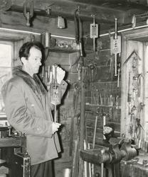 To menn viser frem verktøysamlingen til O. Kjellstad i Helle