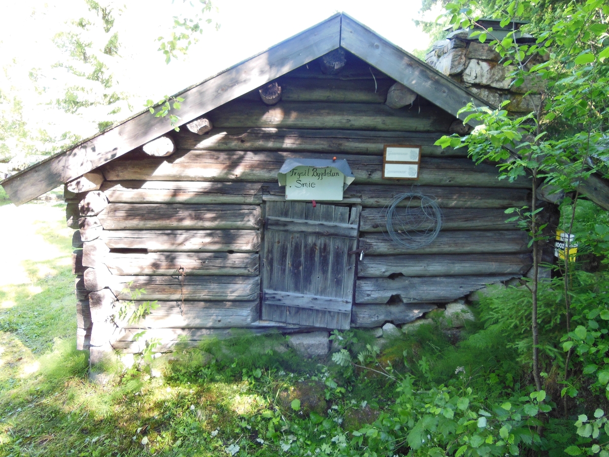 Et laftet tømmerhus med stikketak og dør i gavlveggen. Essa er plassert i hjørnet til høyre for døra.