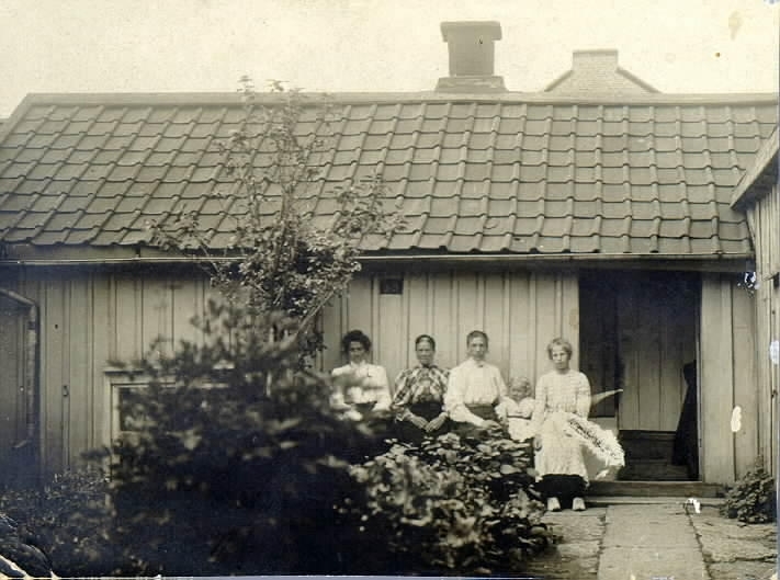Framför Nilssonska bageriet. Från höger: Thyra Larsson, Karin Larsson, gift Roos, Maria Larsson (mor till den förra) "Mjölk-Mari", fru Kristina Nilsson (trol.)? 5. Maria Larssons äldsta dotter.