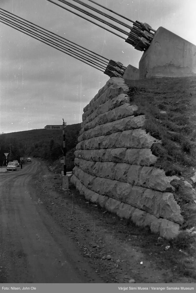 Begynnelsen av bruspennet på Tana bru på østsida. Den gamle grusveien retning Seida og Luftjok. 26. juni 1966.
