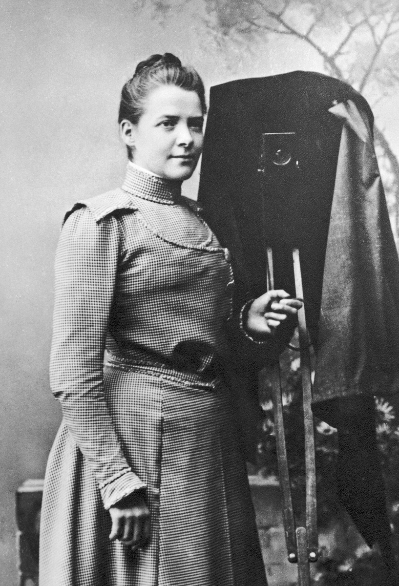 Fotograf Calla Sundbeck bredvid sin kamera. Hon hade sin fotoateljé i Gränna mellan åren 1892-1930.