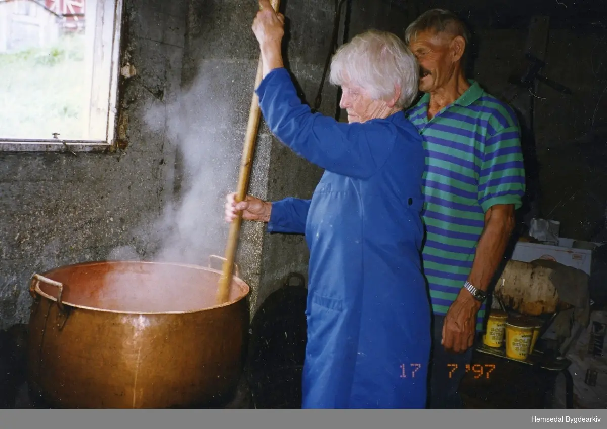 Maria Dalene, fødd Venås 1920, og Anfinn Dalene, fødd 1916, kokar mjølkeprim på Bergastølen i Hemsedal i 1997.