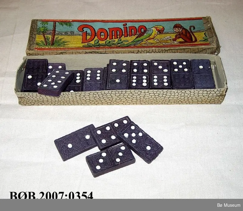 Motiv på loket: Papegøye og apekatt som spelar domino.