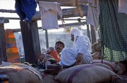 Mann hviler på sekker.