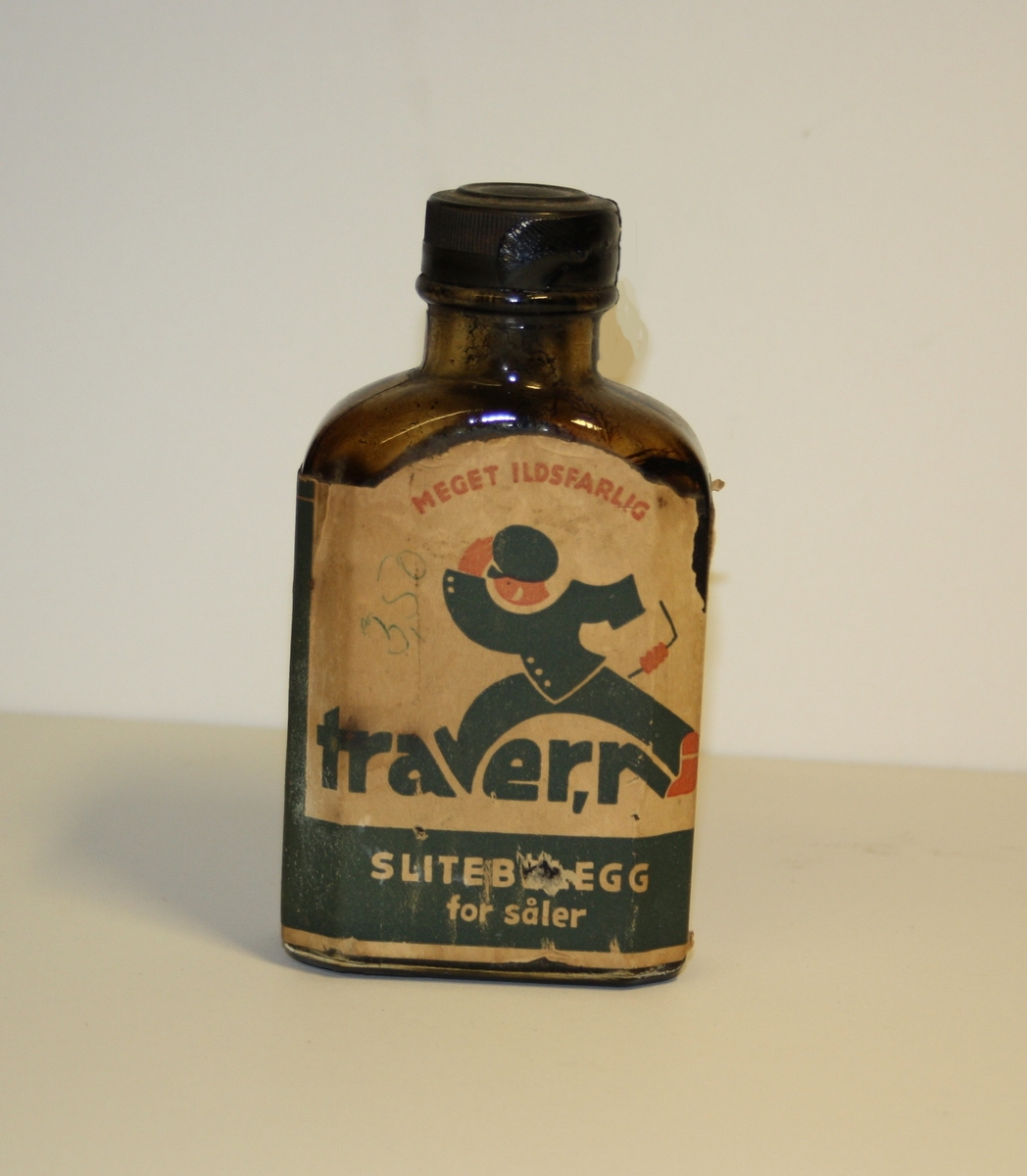 Form: Lita flat flaske med skrukork og pålimt etikett.