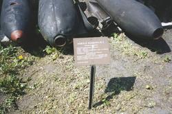 Landskap. Tre missiler ligger på bakken til beskuelse. Disse