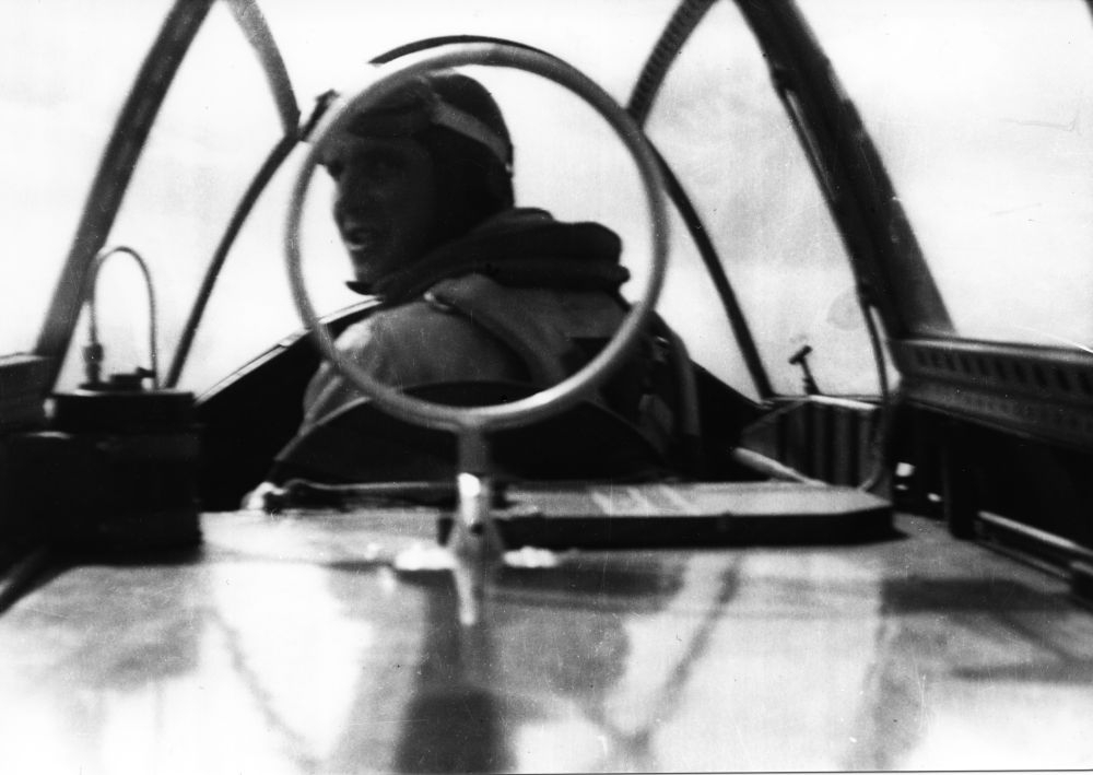 Luftfoto. En person, flyger/pilot, i cockpit ombord et militært fly.