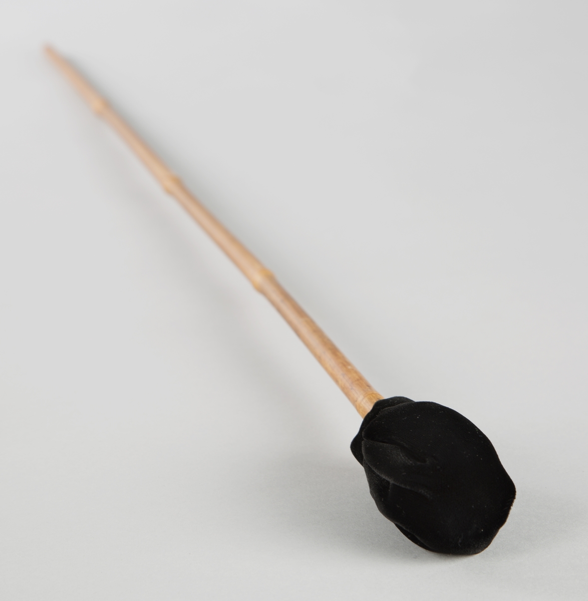 Stikke av bambus, med polstret tupp. Stikken brukes til å spille på eolsklokkene.