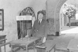 Portvakten Haakon Bø stående i Bergensporten, bygning nr. 30