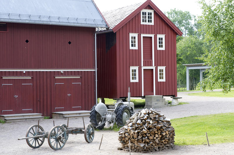 Gårdstun fra Trøndelag. En vedstabel og traktoren Gråtass står på tunet.. Foto/Photo