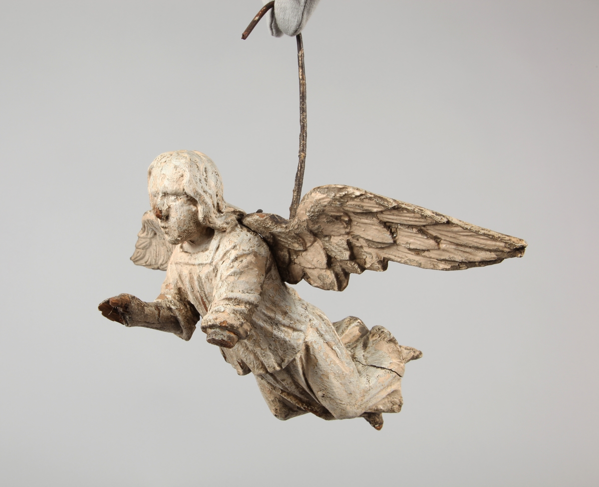 Engleskulptur hengende i en jernbøyle. Vingene er skåret separat og naglet til kroppen.