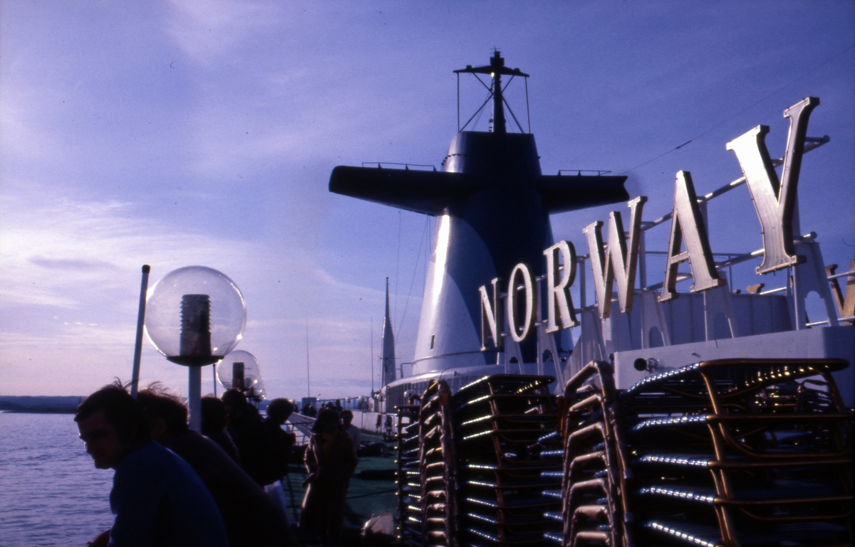 Passasjerene samles på dekk sett under innfarten til S/S ‘Norway’ (ex. ‘France’)(b.1961, Chantiers de l’Atlantique).