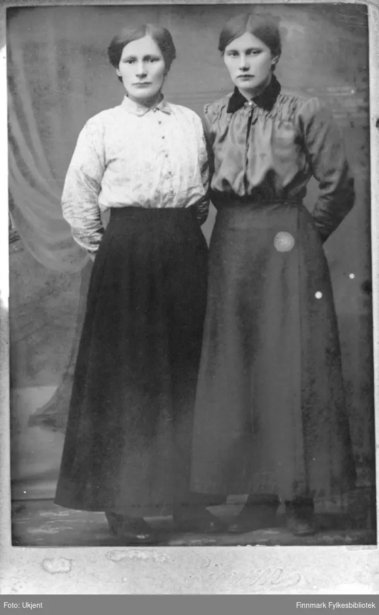 Søstrene Amundsen. Til venstre står Berit Amundsen og til høyre Inga Amundsen. Sammen arbeidet de i fiskeforedlingsindustrien. De  drev også et småbruk sammen med broren,  Anders Amundsen i Nuvsvåg. 