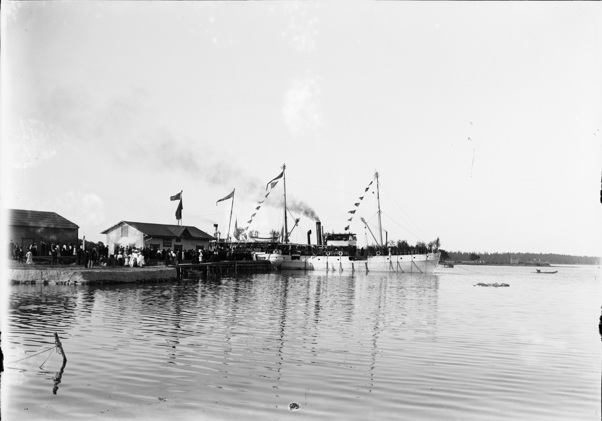 "Ångfartyget Östhammar I prydd med flaggspel lämnar Östhammars hamn", Uppland 1900