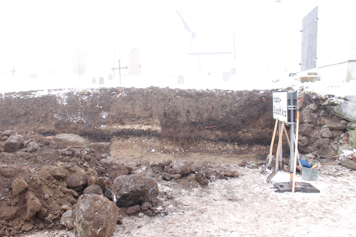Arkeologisk schaktningsövervakning, blottlagd sektion i västra bogårdsmuren, Husby-Sjutofts kyrka, Husby-Sjutolfts socken, Uppland 2016