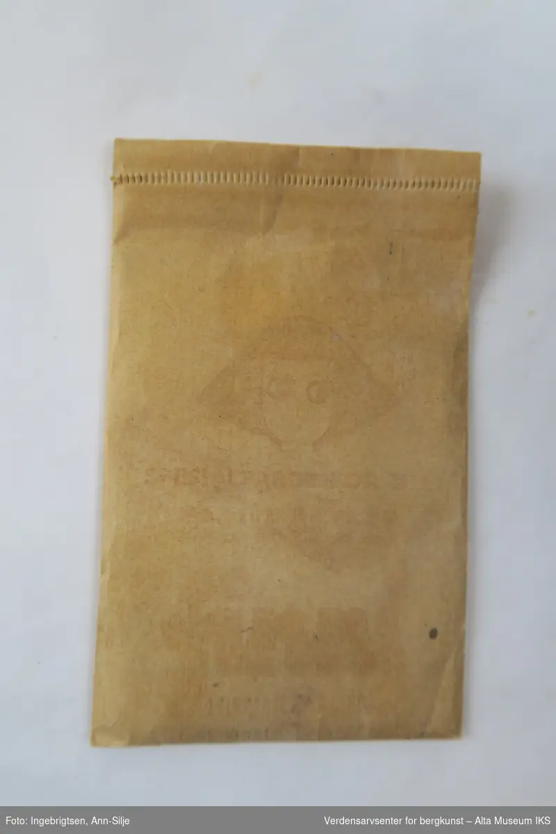 Rektangulær papirpose med pulver. Motiv av en kvinne på forsiden.