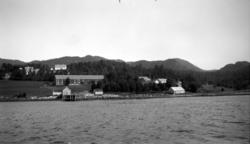 Kulturlandskap med blant annet en kai og en låve. Fra Nordmø