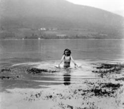 En badende nymfe ute i fjorden, omgitt av tang, ukjent hvor.