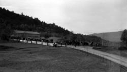 Fotografi av et følge med mennesker og hester. Kan bildet væ