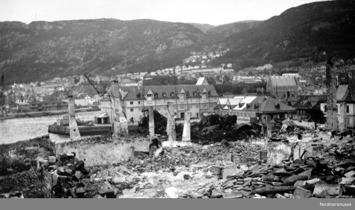 
Foto fra et tettsted i ruiner. - Dette er fra bydelen Nordnes i Bergen, som ble bombet av britiske fly i april 1940. Den intakte bygningen i bakgrunnen står på Tollbodkaien. (Informant: Arne Stein Pedersen.)





