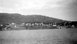 Foto fra ei bygd, sett fra andre siden av fjorden. Kan det v
