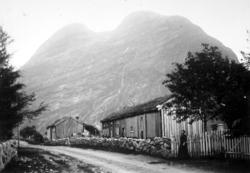 Foto fra en landevei, hvor vi ser fra gamle gårdshus i tømme