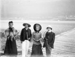 Foto av en gruppe utkledte
barn ved et kaianlegg, med ei byg