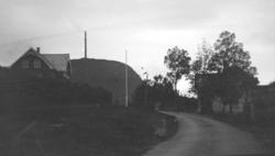 Bolighus på hver side av en vei. Fra Nordmøre museums fotosa