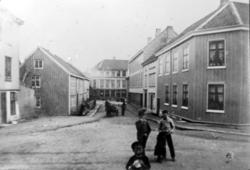 Gatefoto, muligens fra Kristiansund by, hvor vi ser noen bar