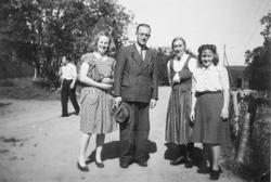 Mann og tre kvinner på en vei.