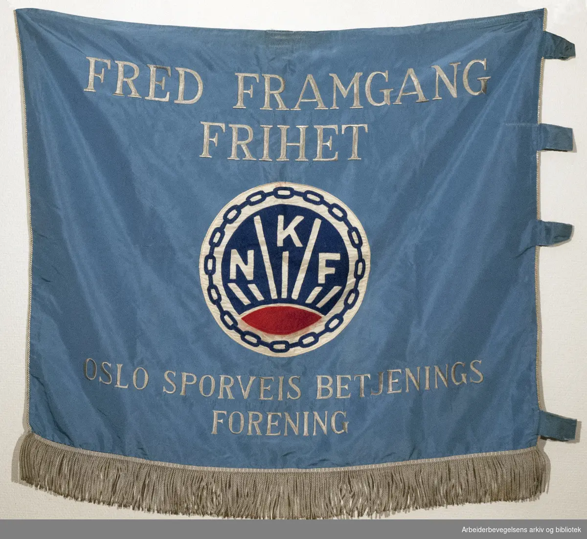 Oslo Sporveis Betjenings Forening..Bakside..Fanetekst: Fred Framgang Frihet.NKF.Oslo Sporveis Betjenings Forening