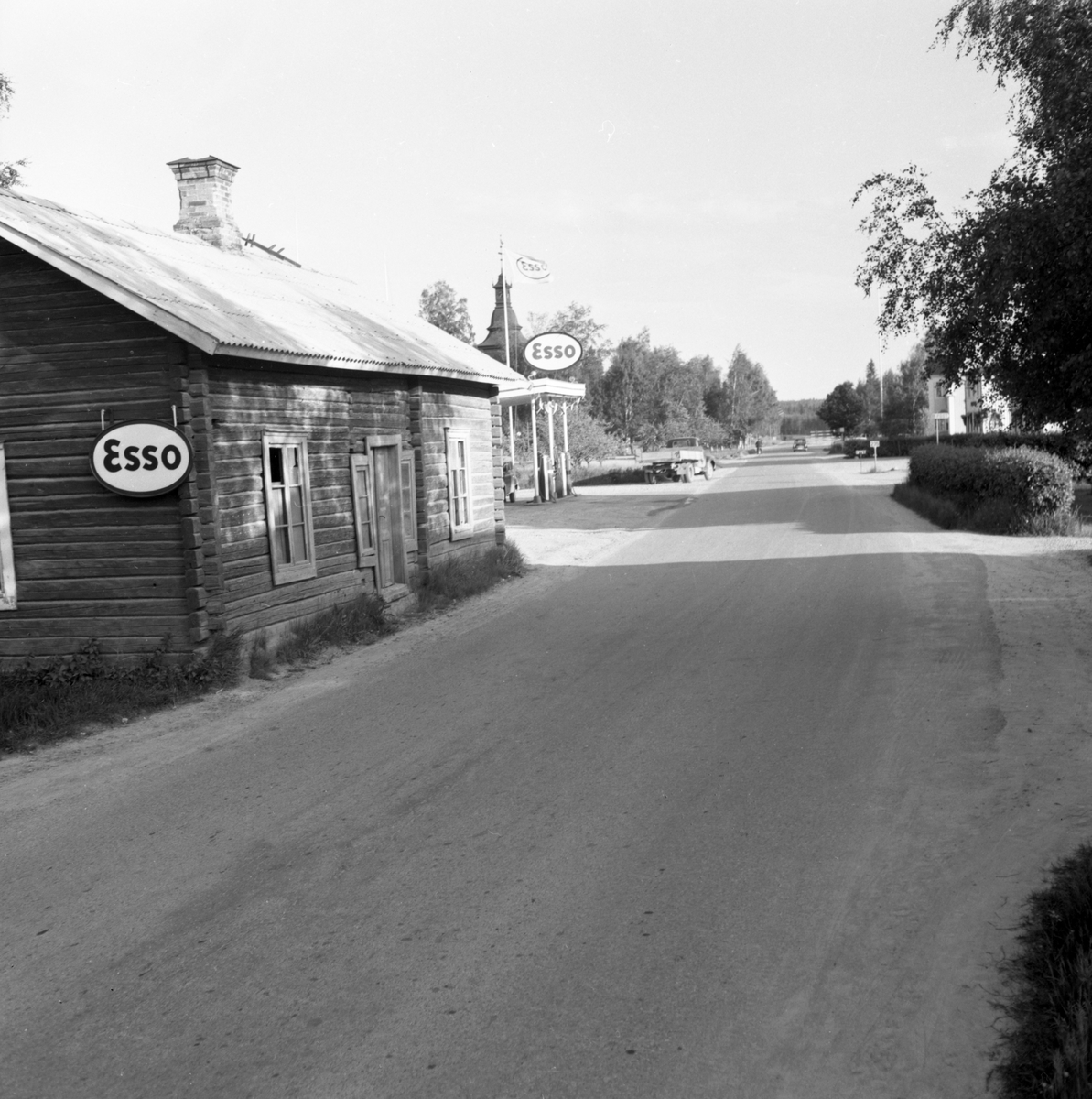 Någonstans i Värmland - från slutet av 1950-talet. Kommentar från en användare: "Ekshärad, kyrkan syns till vänster. Bilden tagen ungefär vid nuvarande Statoil".