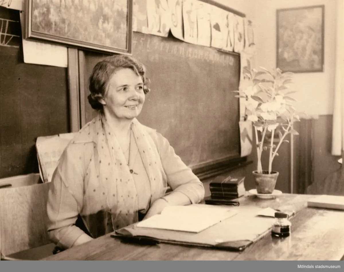 Lärarinnan Agda Carlson vid katedern i Grevedämmets skola i Mölndal, ca 1950.

För mer information om bilden se under tilläggsinformation.