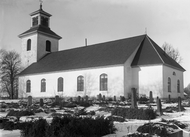 Foto av Nöbbele kyrka (?) med kyrkogård. Vinterbild.