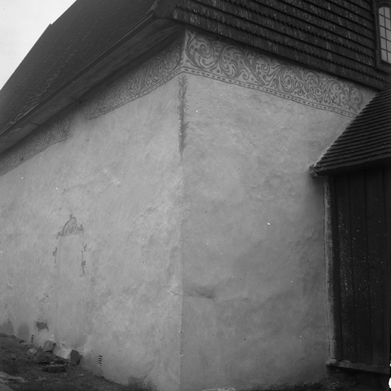 En kyrkvägg med en gammal fasaddekoration (vid takkanten). Sjösås gamla kyrka. 1943.