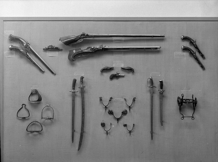Ett antal stigbyglar, gevär, sablar och ryttarpistoler m.m. i den 
Historiska avdelningen på Smålands Museum.