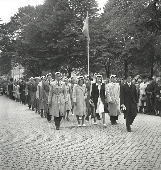 300-årsjubileet, 1943. 
Marsch med en mängd herrar och damer i rock och studentmössa m.m., 
på väg in i domkyrkan. 

Växjö Gymnasiums 300-årsjubileum. (AB).