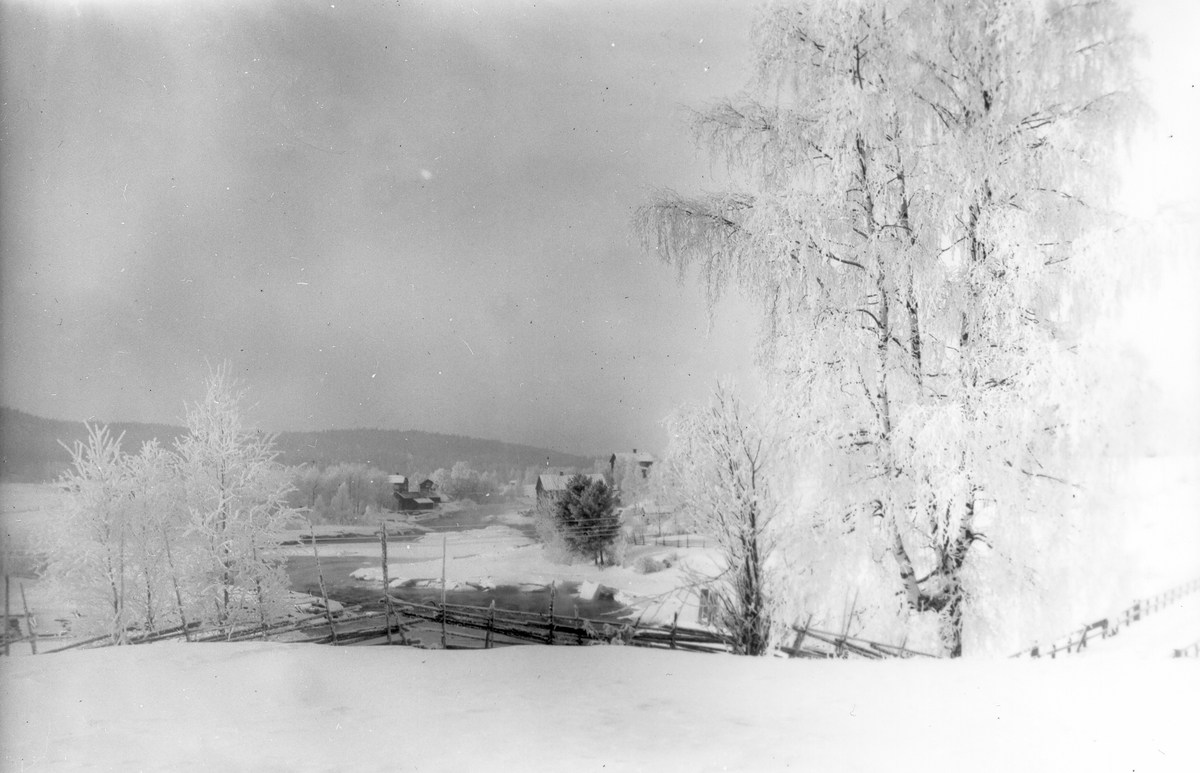 Vintervy över Voxna älv, tagen från "Skinnar-kullen". I bakgrunden till vänster Lenningefors smedja, till höger kvarnen.