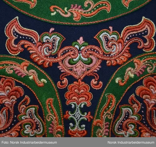 Livet er foret med et ubleket stoff. Livet er mørkt blått med grønn kanting. Både kantene og livet er prydet med plattsøm foran og bak. 
Nederst på stakken er det to border. Den øverste er  i grønt kantet med lilla og orange kontursting. Den nederste er i rødt kantet med gult. Nedenfor bordene ses den mørkeblå stakken. Den er kantet med rødt. 
Det brikkevevde beltet som hører til bunaden er sydd fast i kanten på livet. Borden i midten er orange og svart. På hver ytterside er det en rød, hvit og svart bord. Beltet har også striper i brunt, hvitt, rødt, svart og turkis. Beltet lukkes med hekter. Begge frynseendene på beltet er klipt av. Det ene frynesstykket er montert på beltet, slik at det alltid henger ned langs stakken i samme lengde. Det andre frynsestykket er løst og må festet på beltet med en sikkerhetsnæl eller liknende.