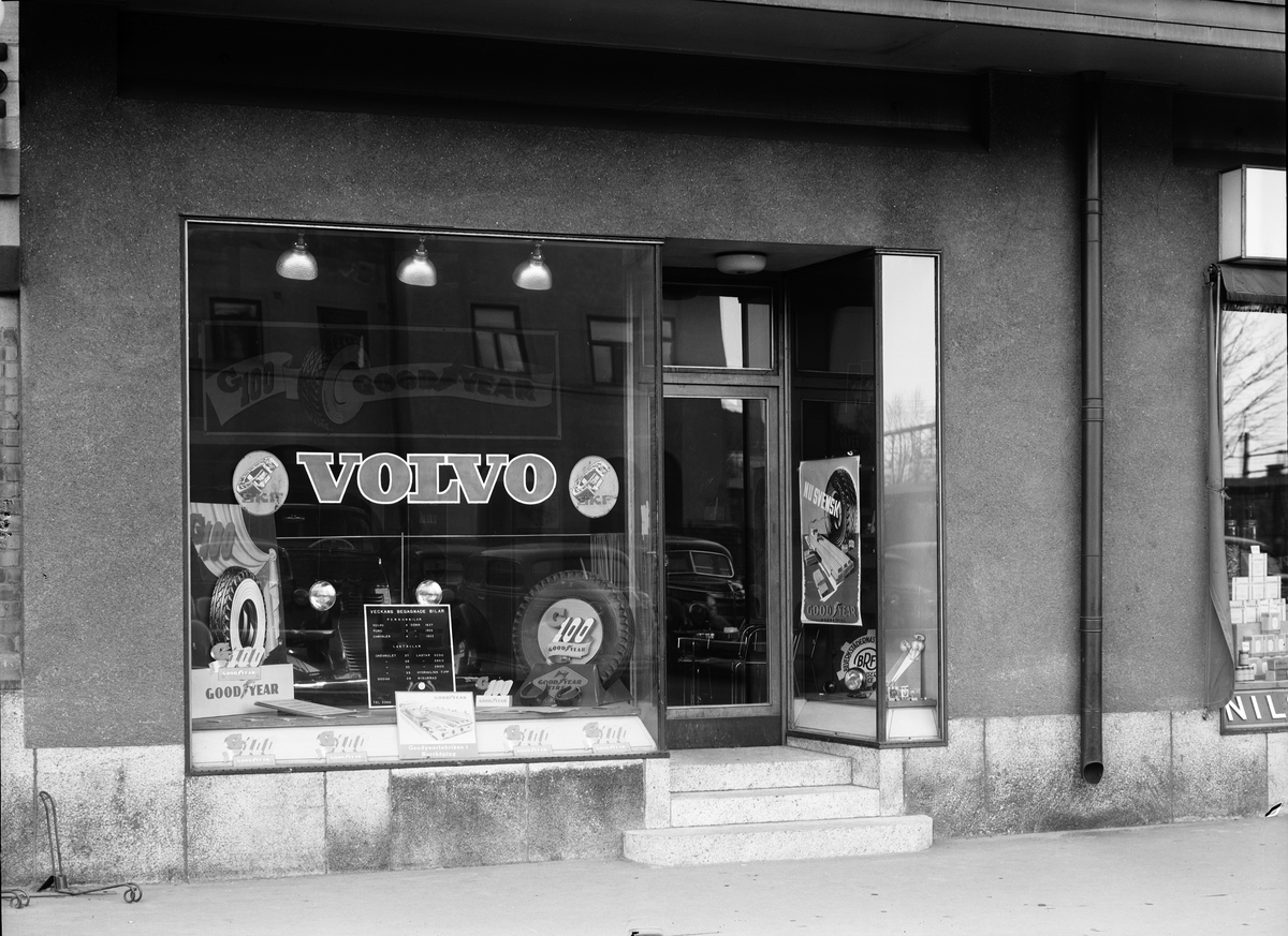 Foto av skyltfönster med reklam för "Volvo", på Centralplan 5. I samma lokal fanns senare AB Norrlands Elektriska. Till höger skymtar Nils Grohmans speceributik. Foto 15 april 1939.